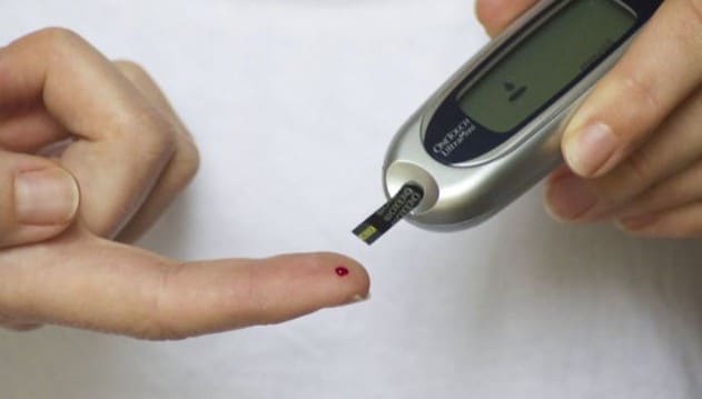 Personne mesurant son taux de glucose dans le sang avec un glucomètre, illustrant le lien entre la consommation de fécules et le diabète.